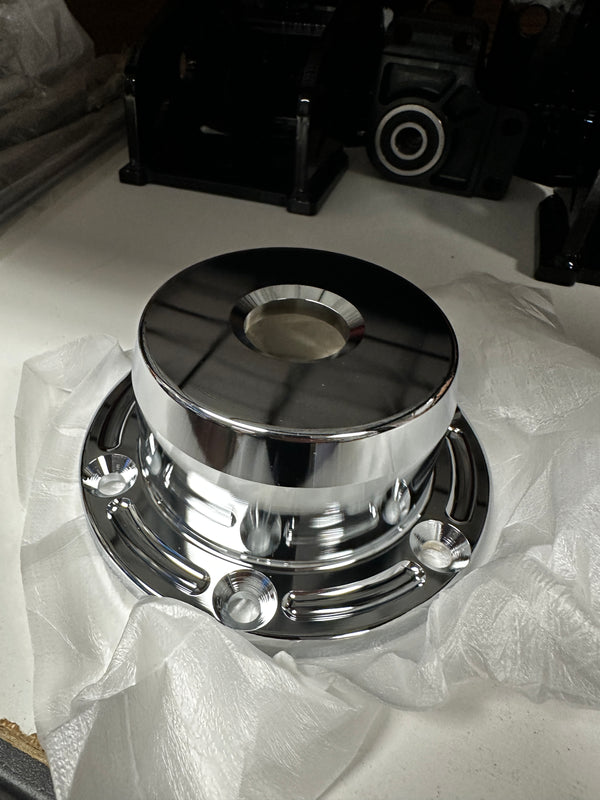 Polished metal custom truck hub part for drivetrain on a workbench with packaging