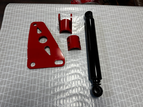 Heavy duty truck suspension parts set with red brackets and black shock absorber on patterned surface