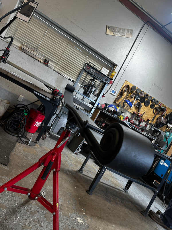 Heavy duty truck leaf spring on red stand in mechanic workshop with tools and equipment
