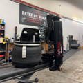 Tire on a lift in a garage with 'Built by Wolf' sign in the background