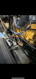 Heavy duty truck engine and suspension components with visible hoses and wiring.