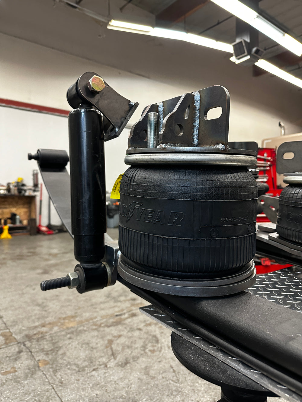 Heavy duty truck suspension airbag and bracket assembly in a repair shop