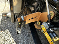 Heavy duty truck suspension bracket and hydraulic lines on gravel surface