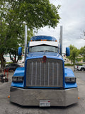 Large blue and gray truck with solar panels on a street