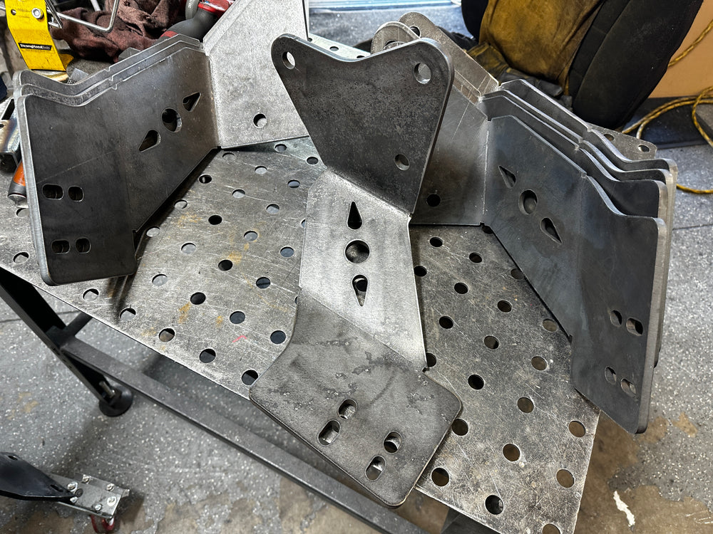 Heavy duty custom metal brackets on a perforated workbench for truck repair fabrication
