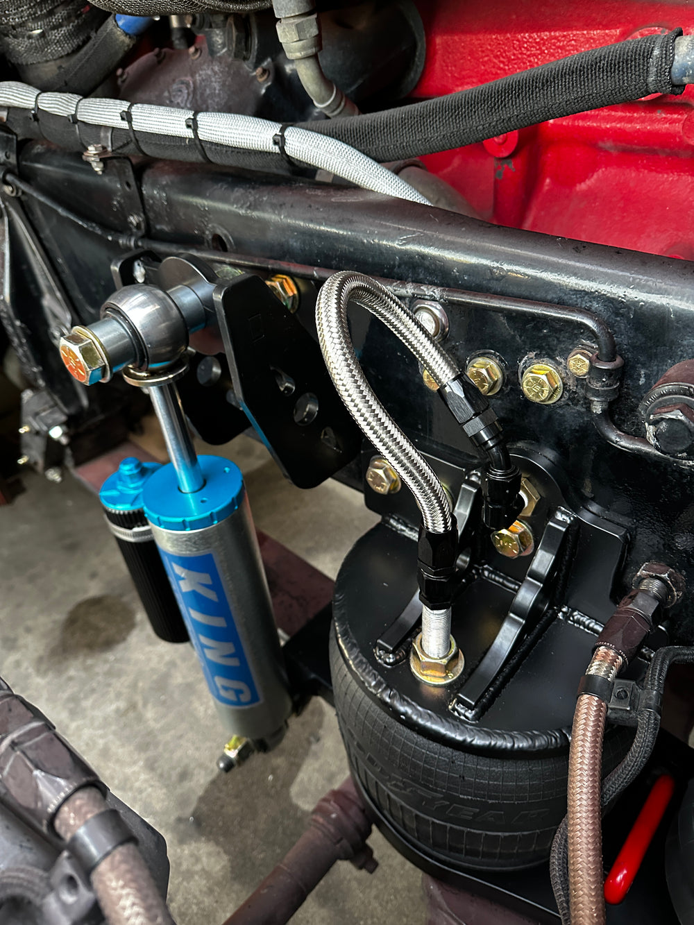 Heavy duty truck suspension with King shock absorber, Goodyear air spring, and braided lines