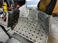 Heavy duty steel truck bracket plates stacked on a metal workbench in a repair shop
