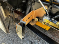 Heavy duty truck chassis with custom metal bracket and hydraulic valve on gravel