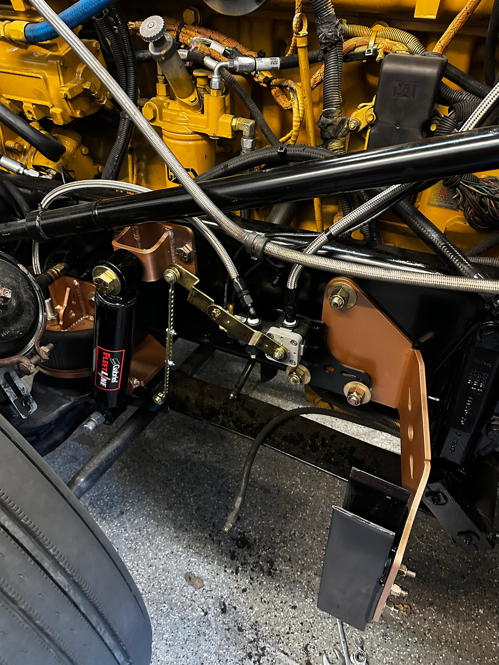 Heavy duty truck engine compartment showing custom fabricated components and suspension parts