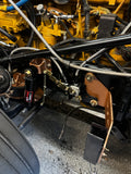 Heavy duty truck engine compartment showing custom fabricated components and suspension parts