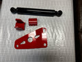 Heavy duty truck suspension components including black shock absorber and red brackets on table