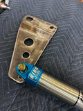 Off-road racing shock absorber and custom metal truck bracket on quilted surface