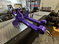Purple heavy duty truck suspension arms on diamond plate in repair shop