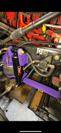 Heavy duty truck suspension upgrade with purple custom brackets and shock absorber
