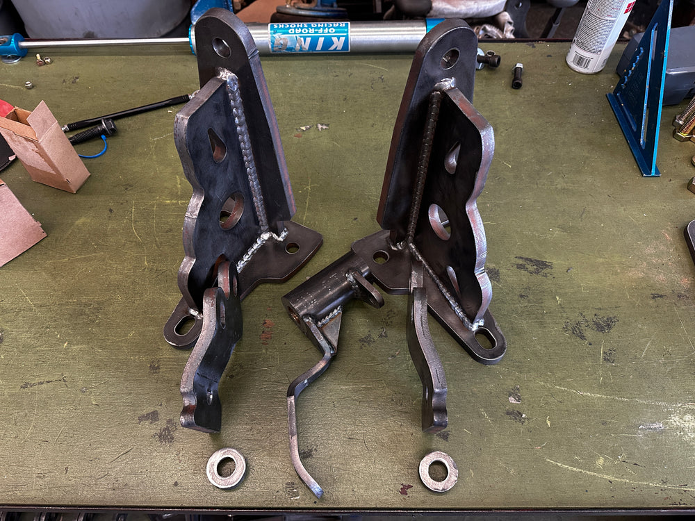 Heavy duty welded steel truck brackets and mounting hardware on workshop table