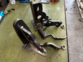 Custom fabricated heavy duty steel brackets for truck repair on a workshop table