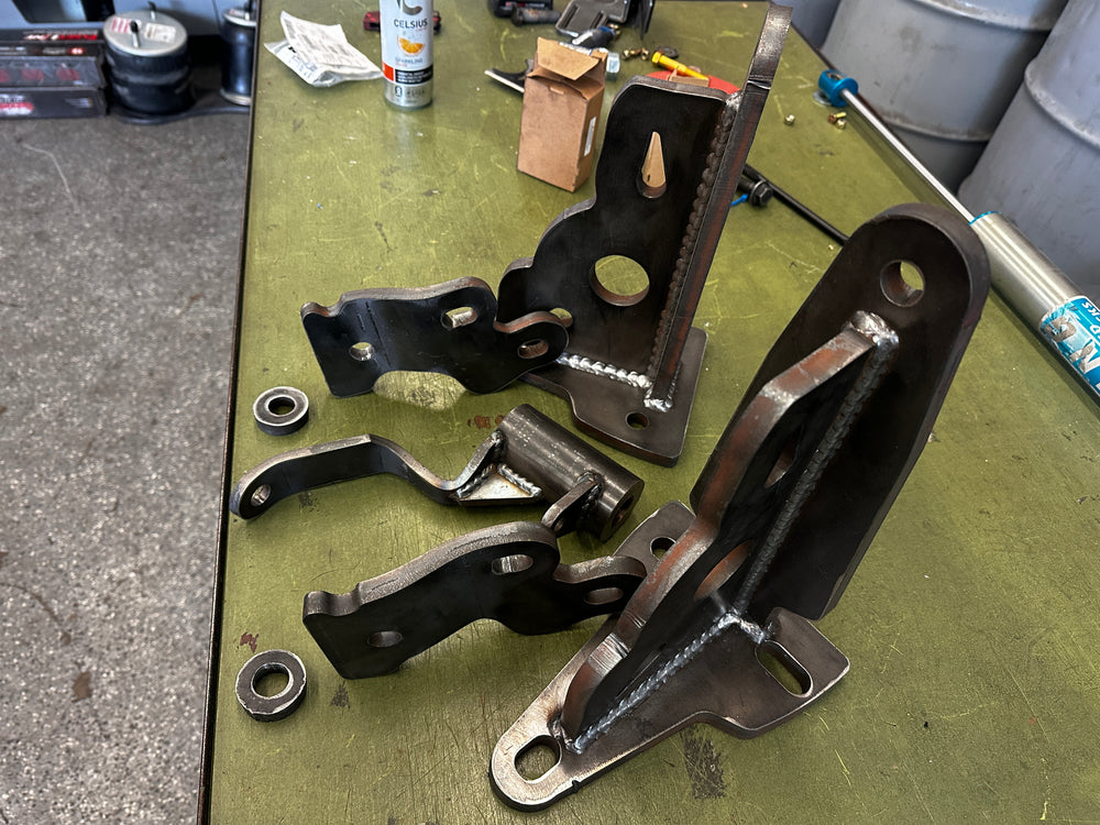 Custom fabricated steel brackets and welds for heavy duty truck repair on workbench