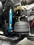 Close-up of a vehicle suspension system with shocks and tires.