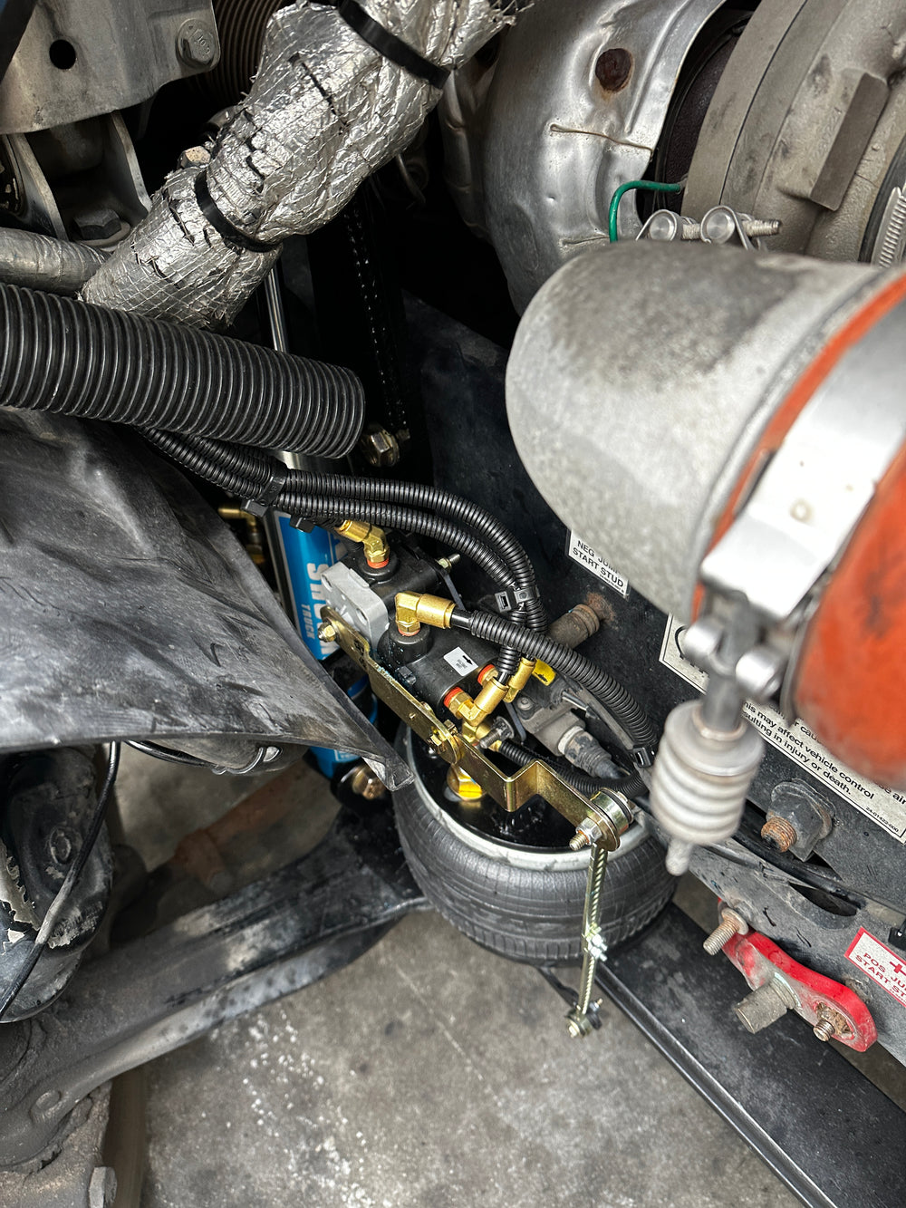 Close-up of a truck air ride system with components like calipers and hoses.